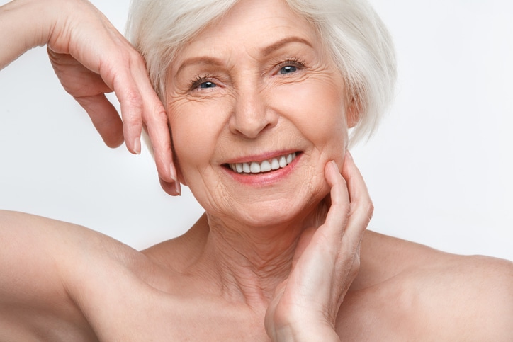 senior woman studio isolated on white wall beauty concept touching face smiling